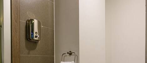 Un baño moderno con un lavamanos blanco, cabina de ducha de vidrio y un inodoro.