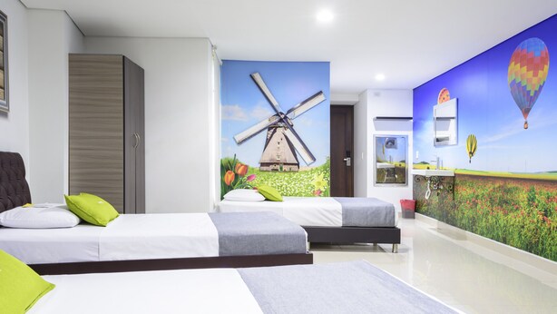 A hotel room with two beds, a wardrobe, a wall mural of a windmill, and a hot air balloon. - 3H Hotel Centro Histórico (Medellín)