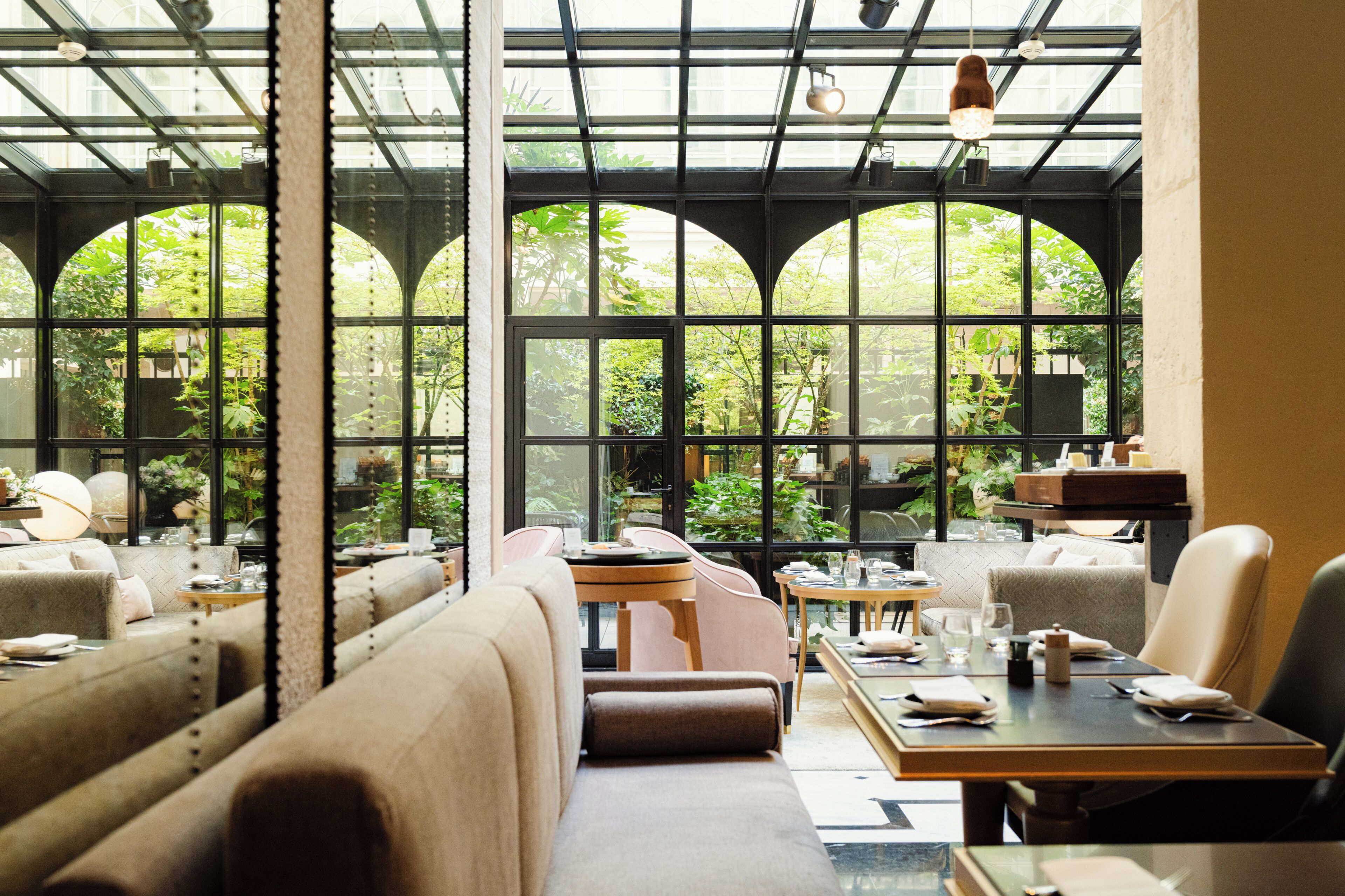 A restaurant with high ceilings, large windows, and a variety of seating arrangements including booths and tables.