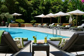 A poolside area with lounge chairs, umbrellas, and a table with drinks. - Le Casablanca Hotel (Casablanca)