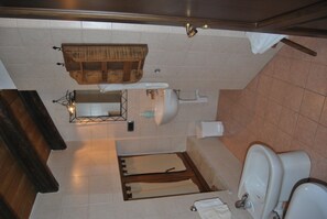 Uma casa de banho com toucador de madeira, pia, sanita e bidé.