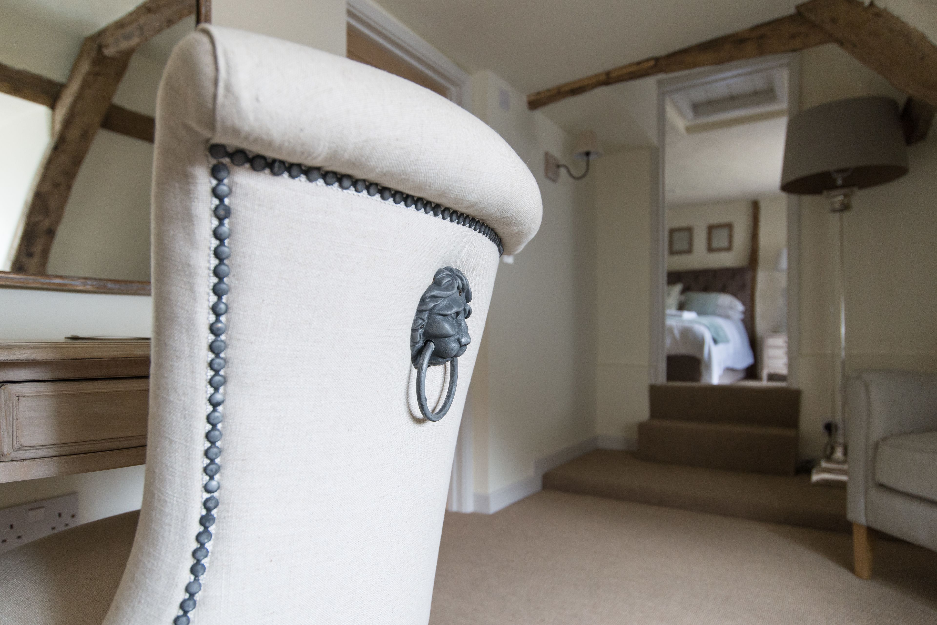 A chair with a beaded trim and a metal ring.