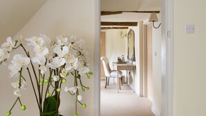 A hallway with a dining area, featuring a table and chairs, and a vase of white orchids. - The Kings Head Bawburgh (Norwich)