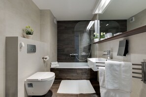 A modern bathroom with a toilet, sink, and shower area.