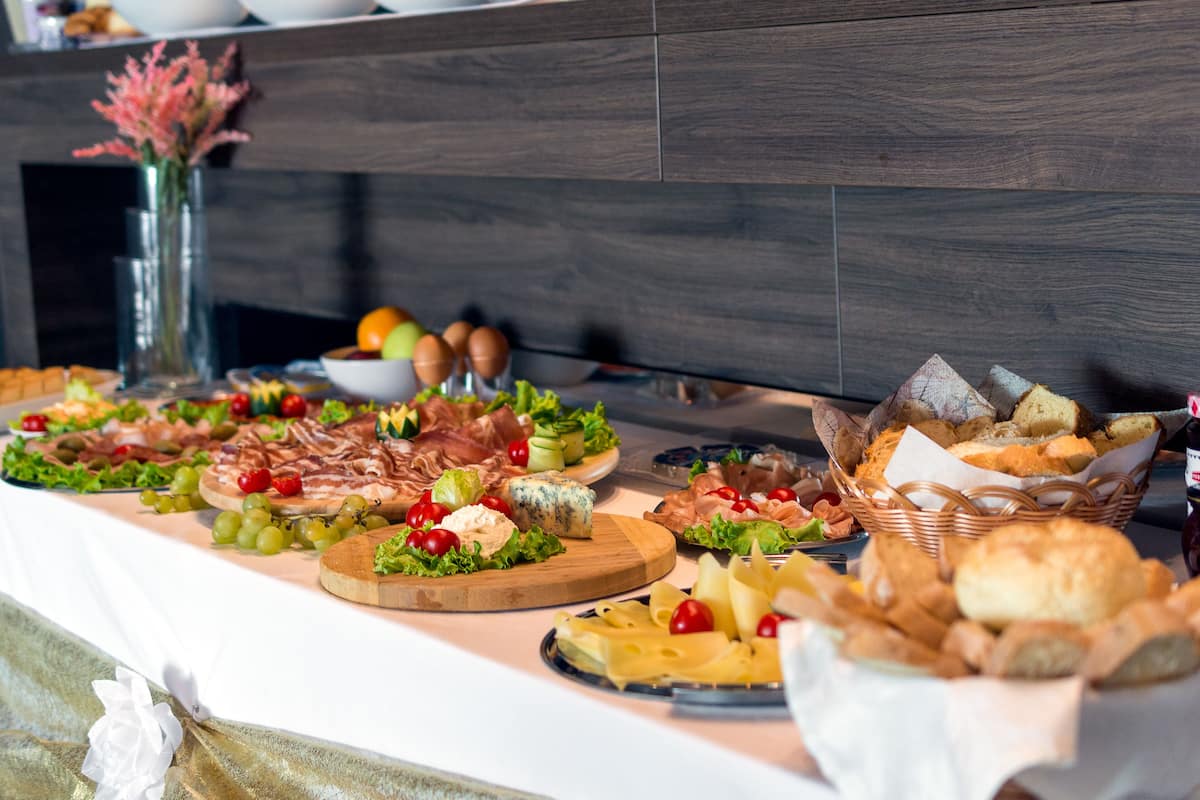 Ein reichhaltiges Buffet mit verschiedenen Speisen, darunter Fleisch, Käse und Brot.