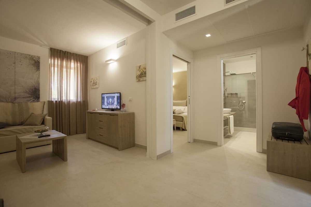 Junior suite, 1 slaapkamer, kitchenette, op benedenverdieping | Woonruimte | Een televisie