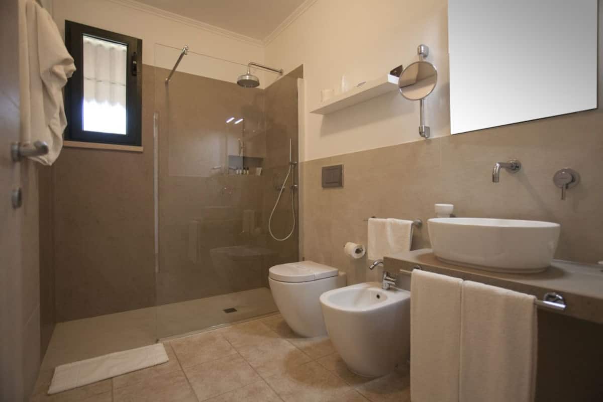 Familiekamer, 2 slaapkamers, uitzicht op tuin | Badkamer | Een regendouche, gratis toiletartikelen, een haardroger, een bidet