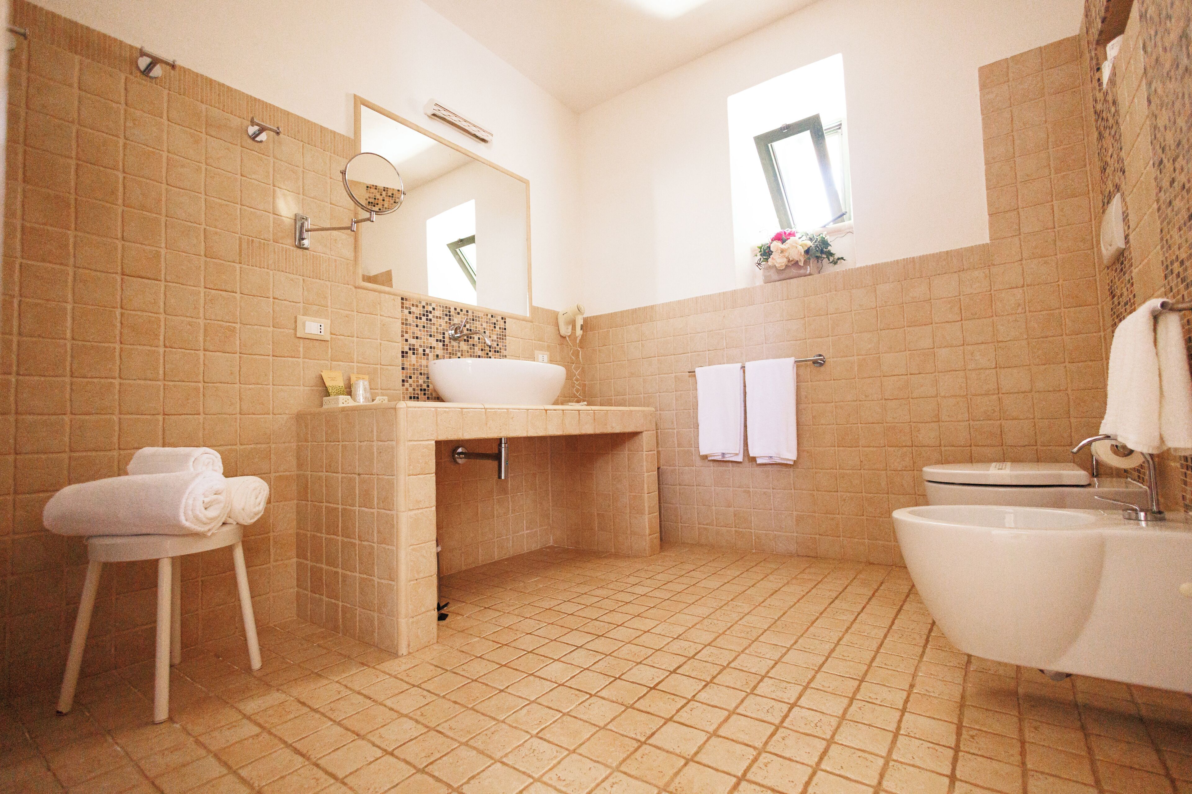 Un baño con lavamanos, inodoro y espejo.