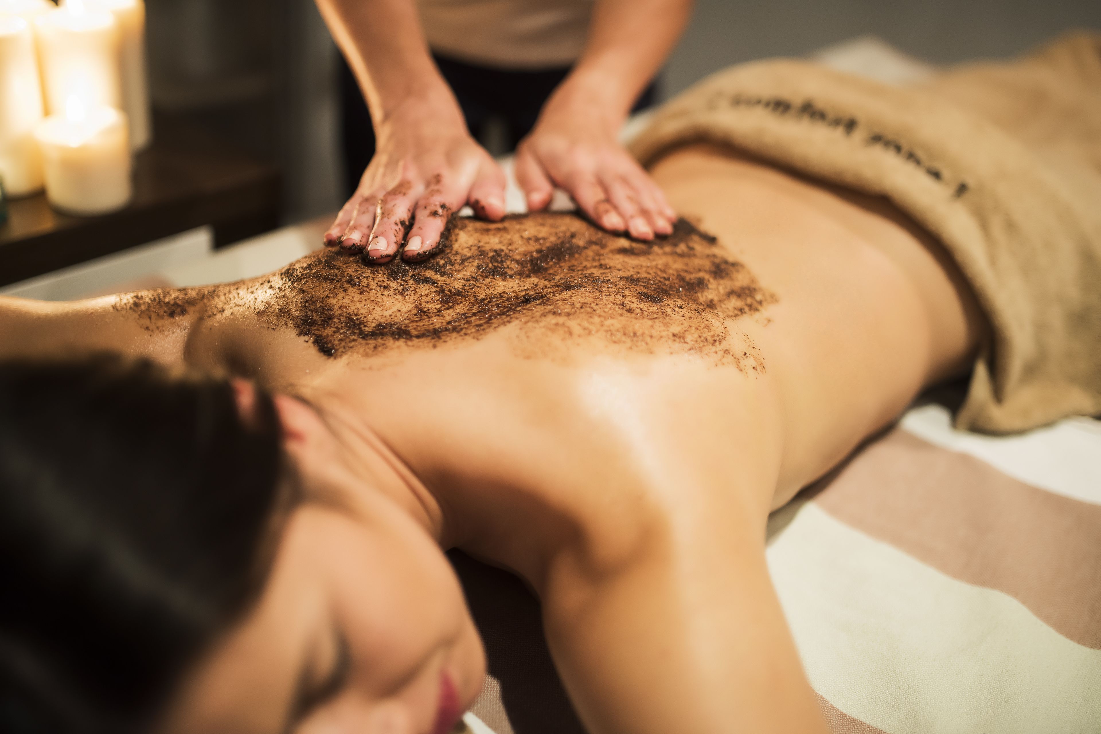 A person receiving a back massage with a powder treatment.