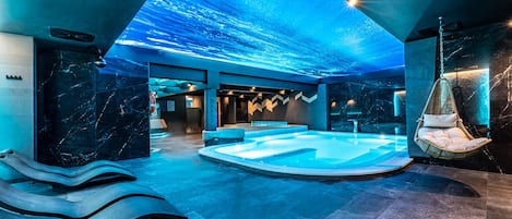 Una piscina techada, sillones reclinables de piscina