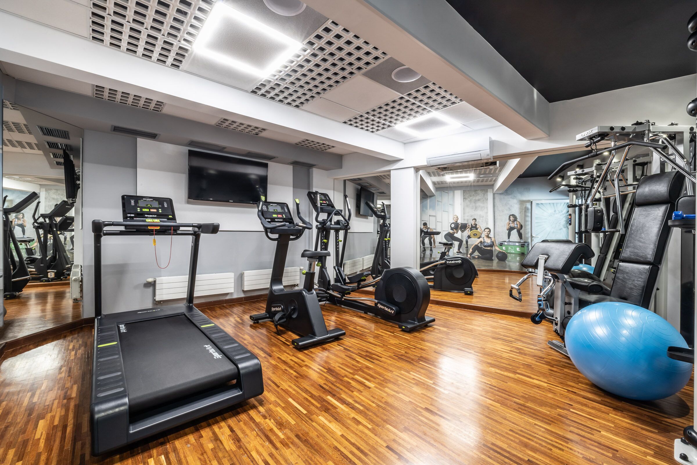 Ein modernes Fitnessstudio mit Laufbändern, Crosstrainern und Kraftgeräten.