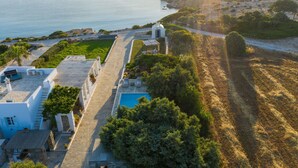 A coastal property with a swimming pool, a covered patio, and a view of the sea. - Amalgam Homes Paros Beachfront Villa (Paros)