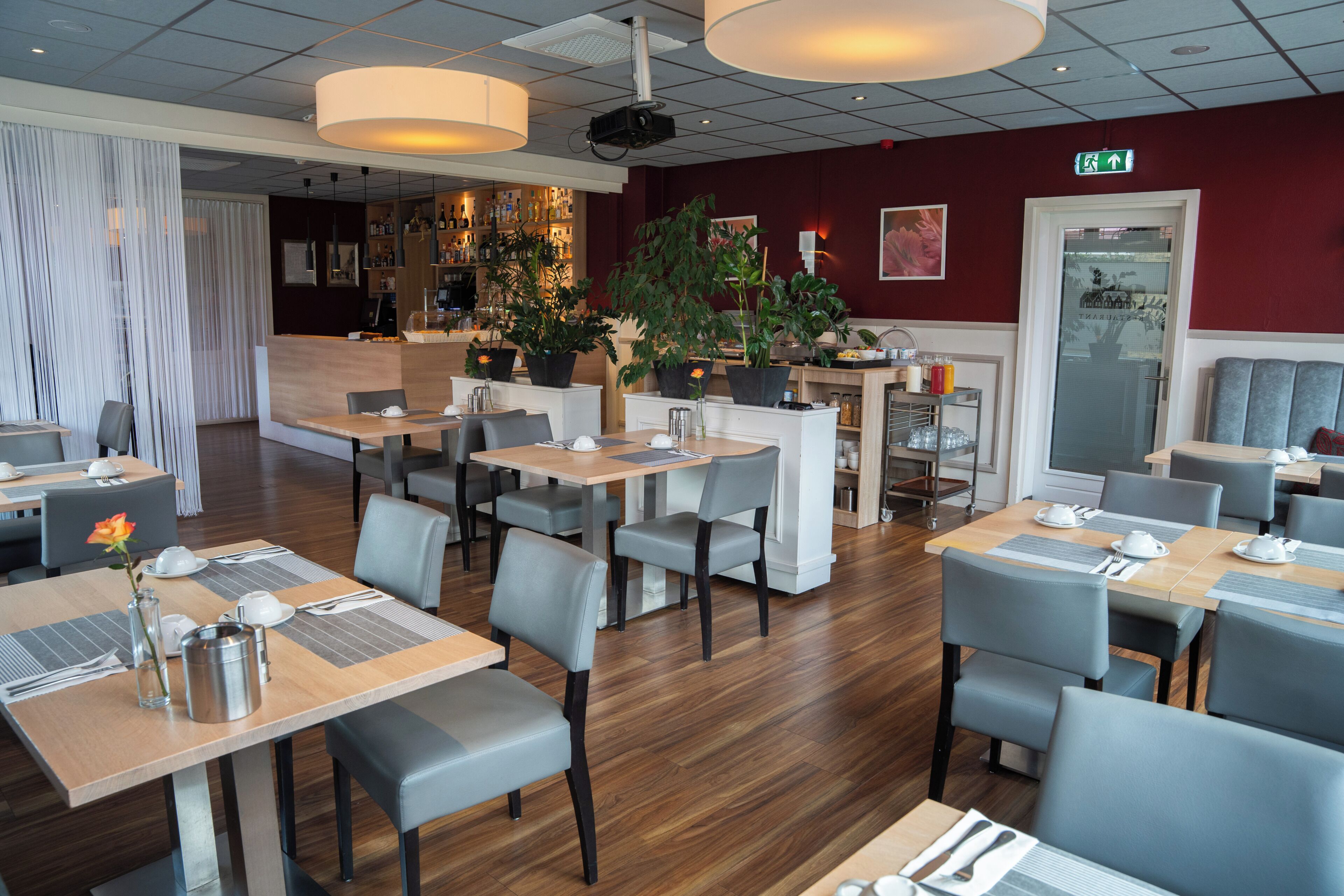 Un restaurant doté de nombreuses tables, de chaises et d’un bar.