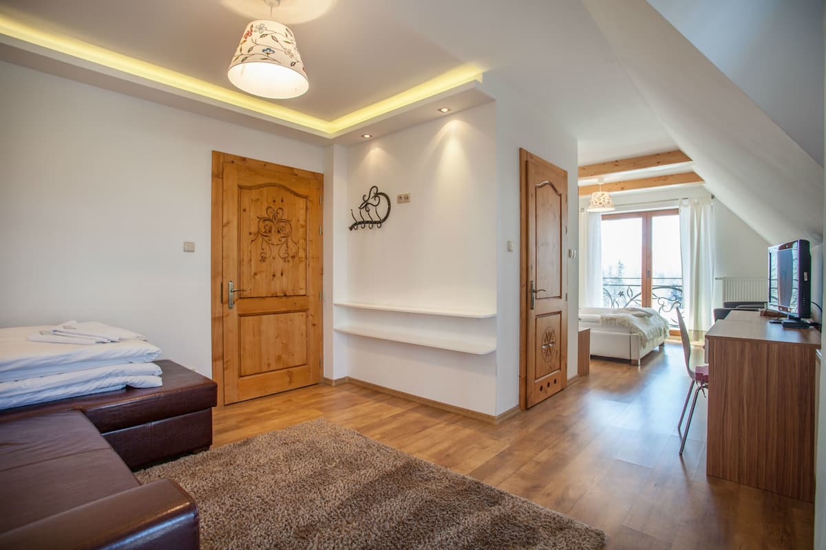 Une chambre moderne avec une armoire en bois, un lit, un bureau et un balcon offrant une vue agréable.