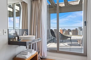 A modern bathroom with a large window, a sink, and a chair outside. - Own Montevideo (Montevideo)