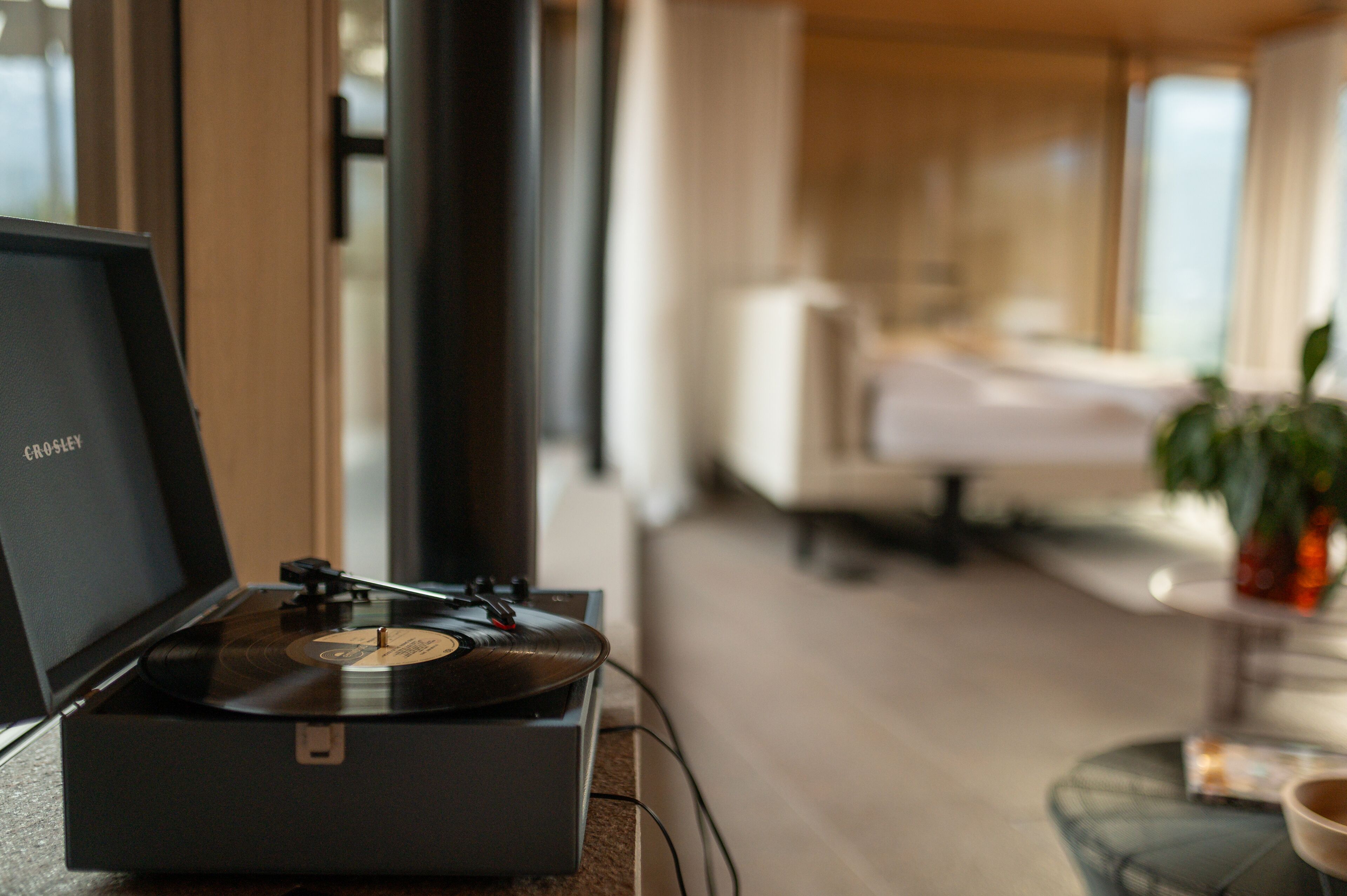 A turntable in a modern living room with a large window, a sofa, and a coffee table.