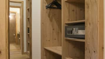 Un armadio in legno con ripiani aperti, un'asta appendiabiti, uno specchio e un pannello di controllo.