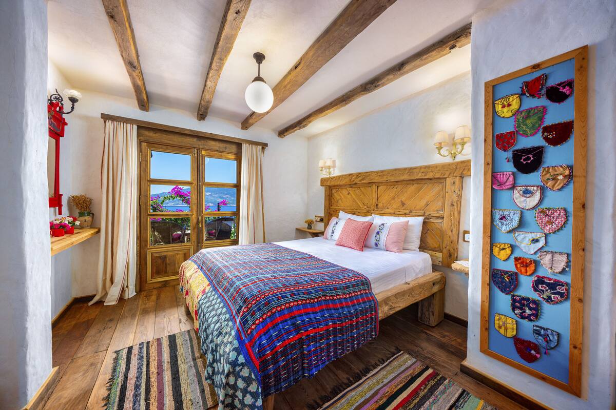 A bedroom with a wooden bed, a large window, and a wall with heart-shaped decorations.