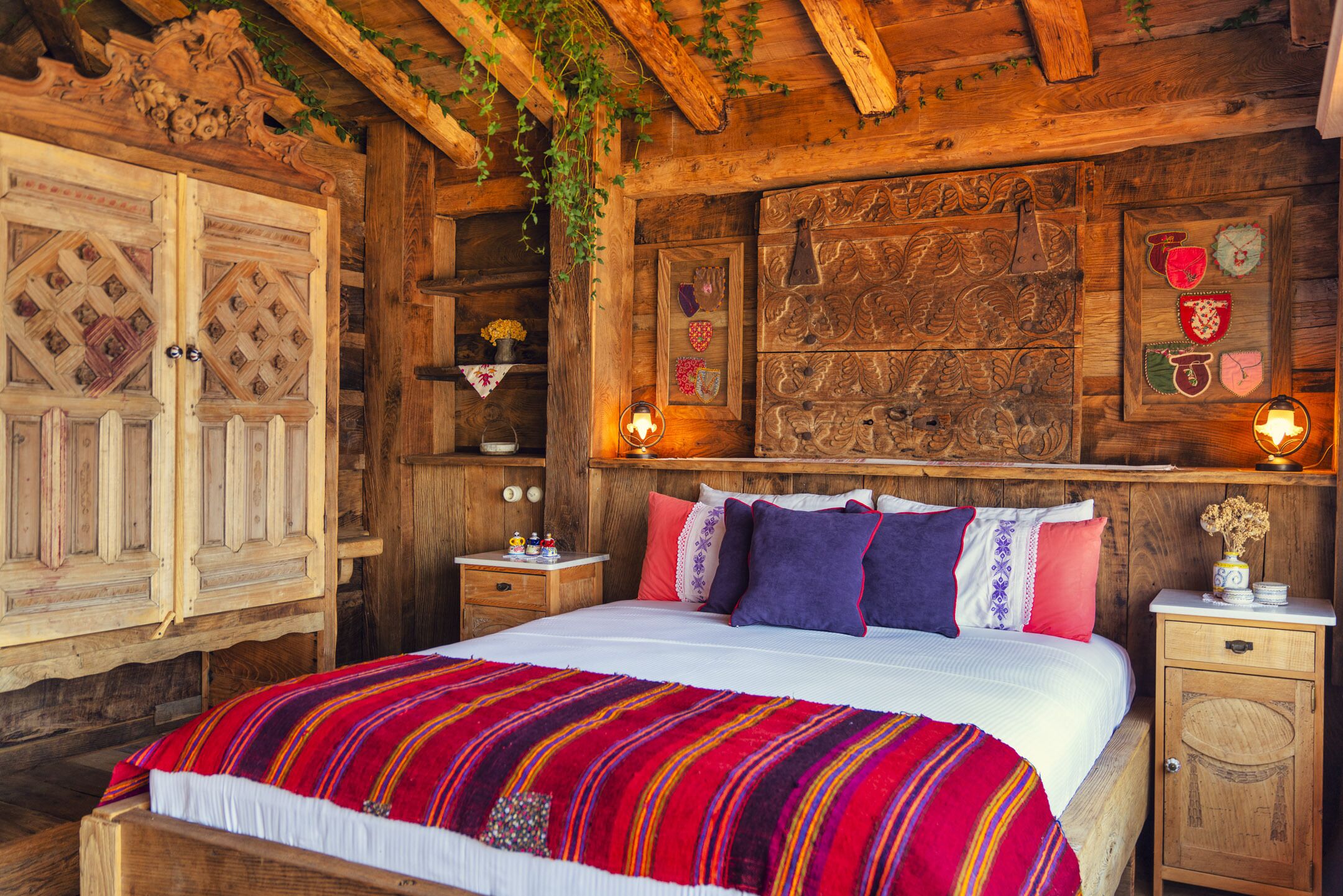 A rustic wooden room with a bed, wooden cabinets, and decorative wall panels.