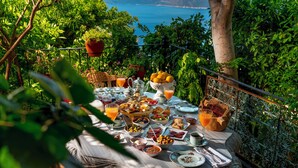 A table set with breakfast items, surrounded by greenery and overlooking a scenic view. - Fidanka Hotel (Kas)