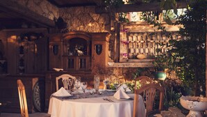 A rustic dining area with a round table set for four, surrounded by wooden chairs. - Fidanka Hotel (Kas)