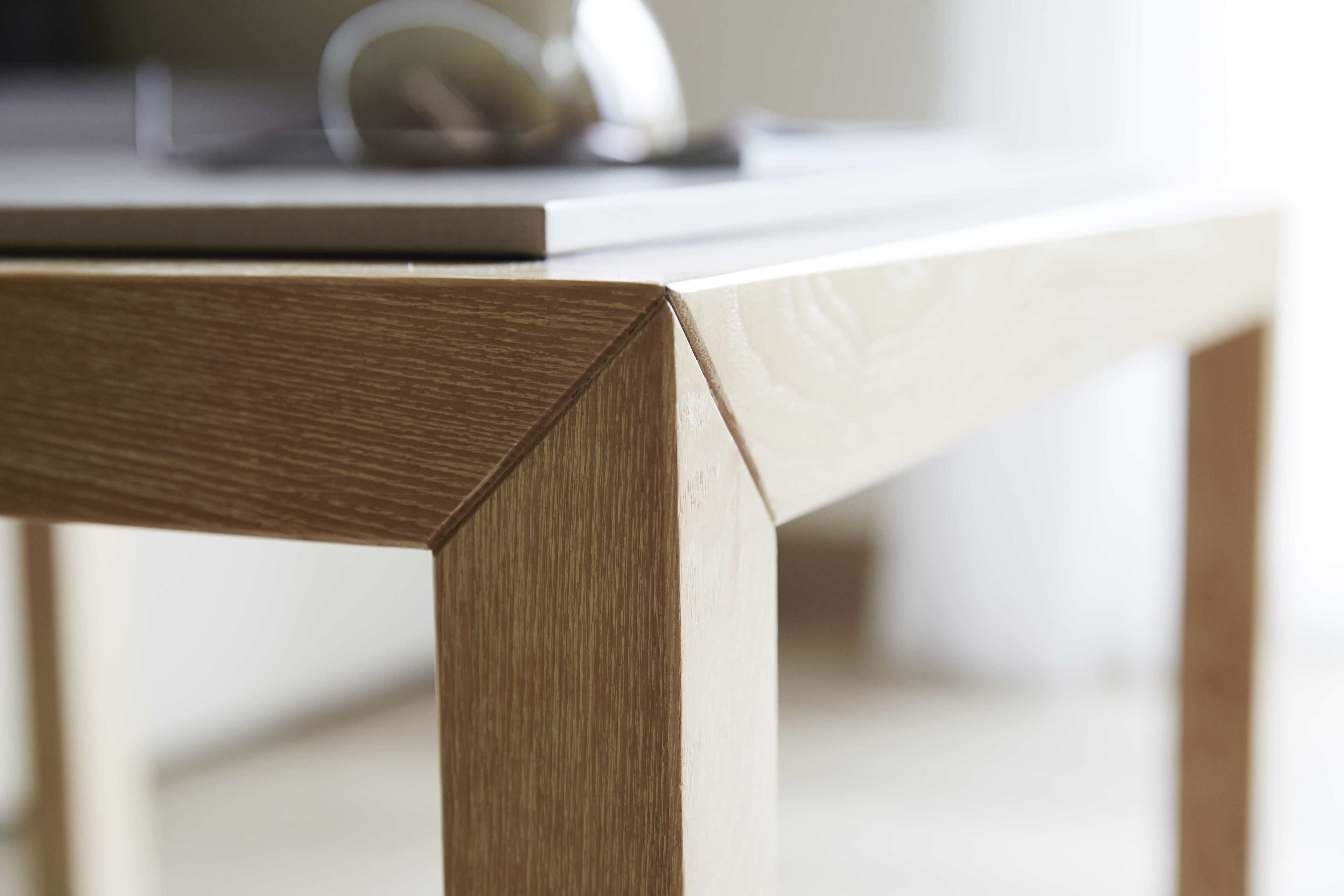 Un primo piano di un angolo di tavolo in legno con un portatile sopra.