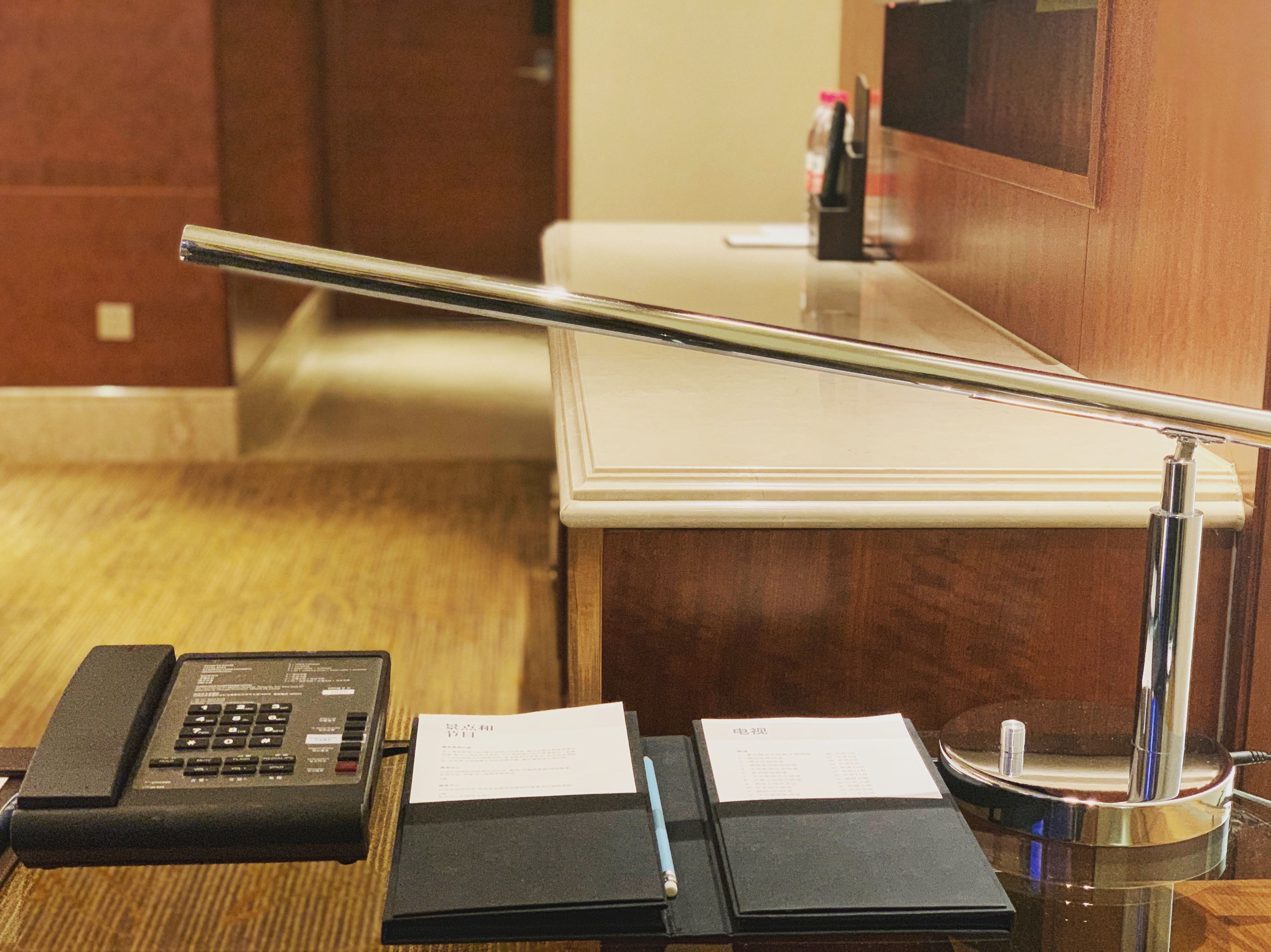 Een hotel receptie met een telefoon, papieren en een pen.