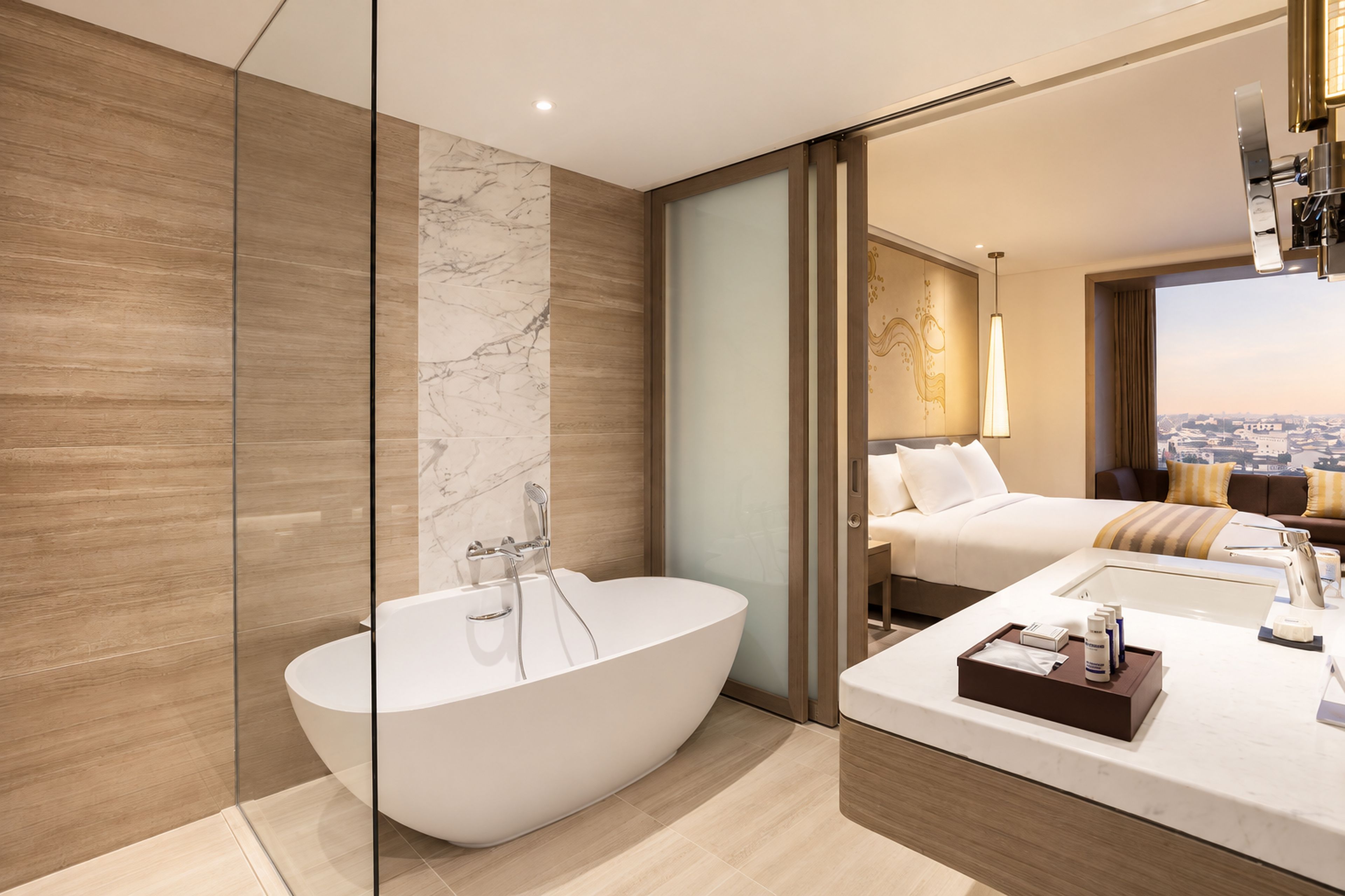 Een moderne badkamer met een vrijstaand bad, een wastafel met spiegel en een bed met uitzicht op de stad.