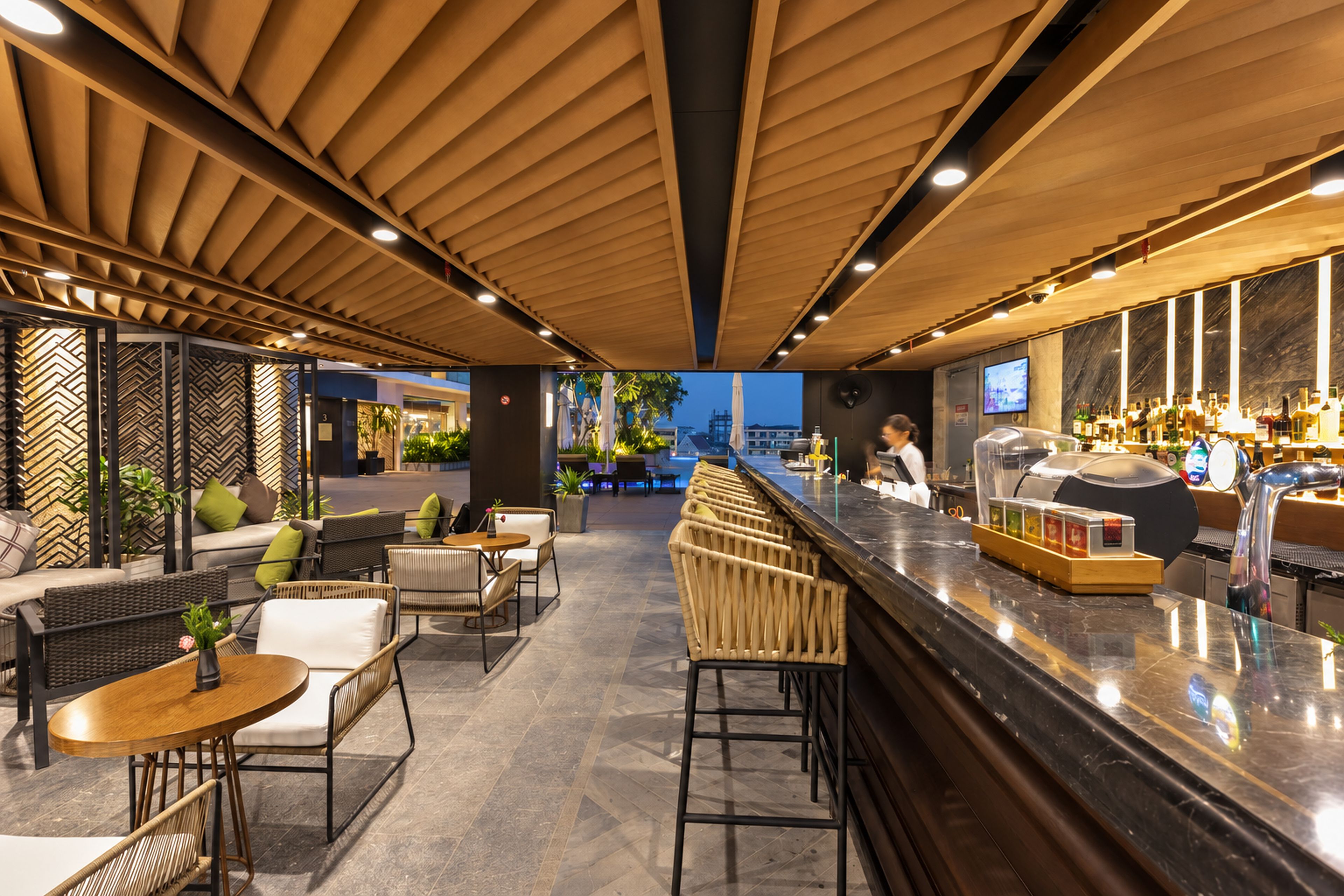 A bar area with seating, a counter, and a view of the outside.