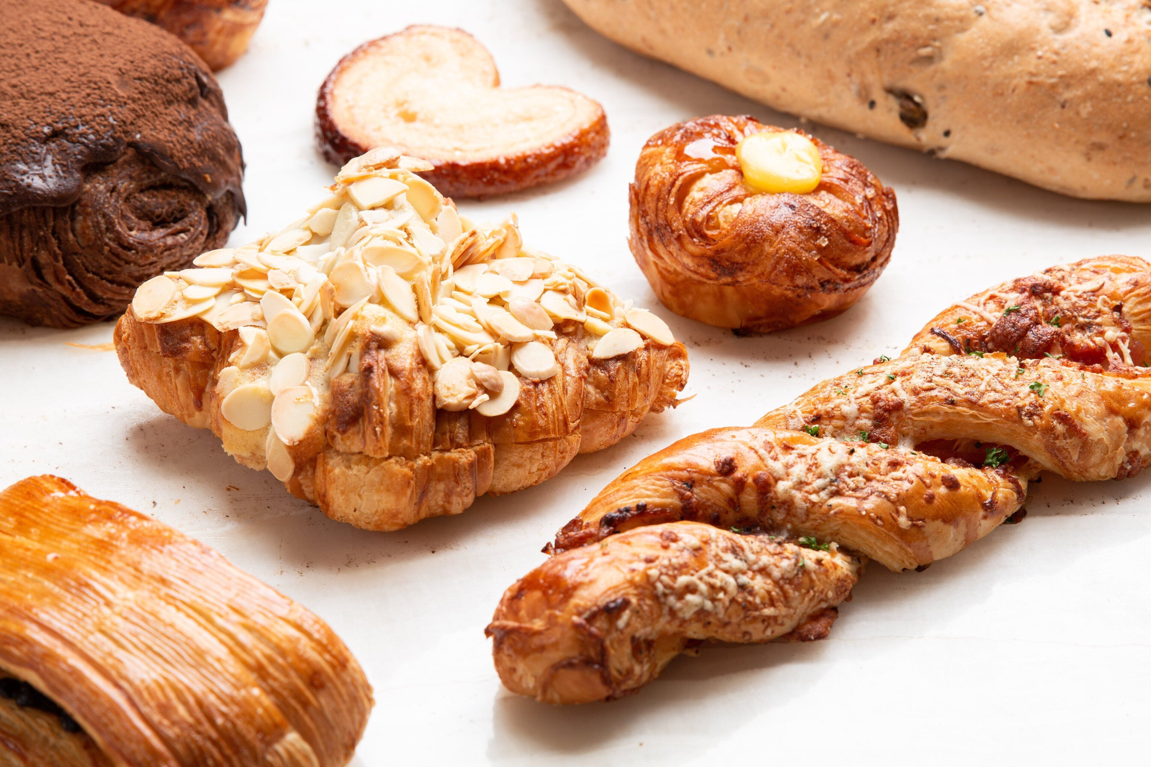 Una variedad de productos de pastelería, incluyendo croissants y un rollo de chocolate.