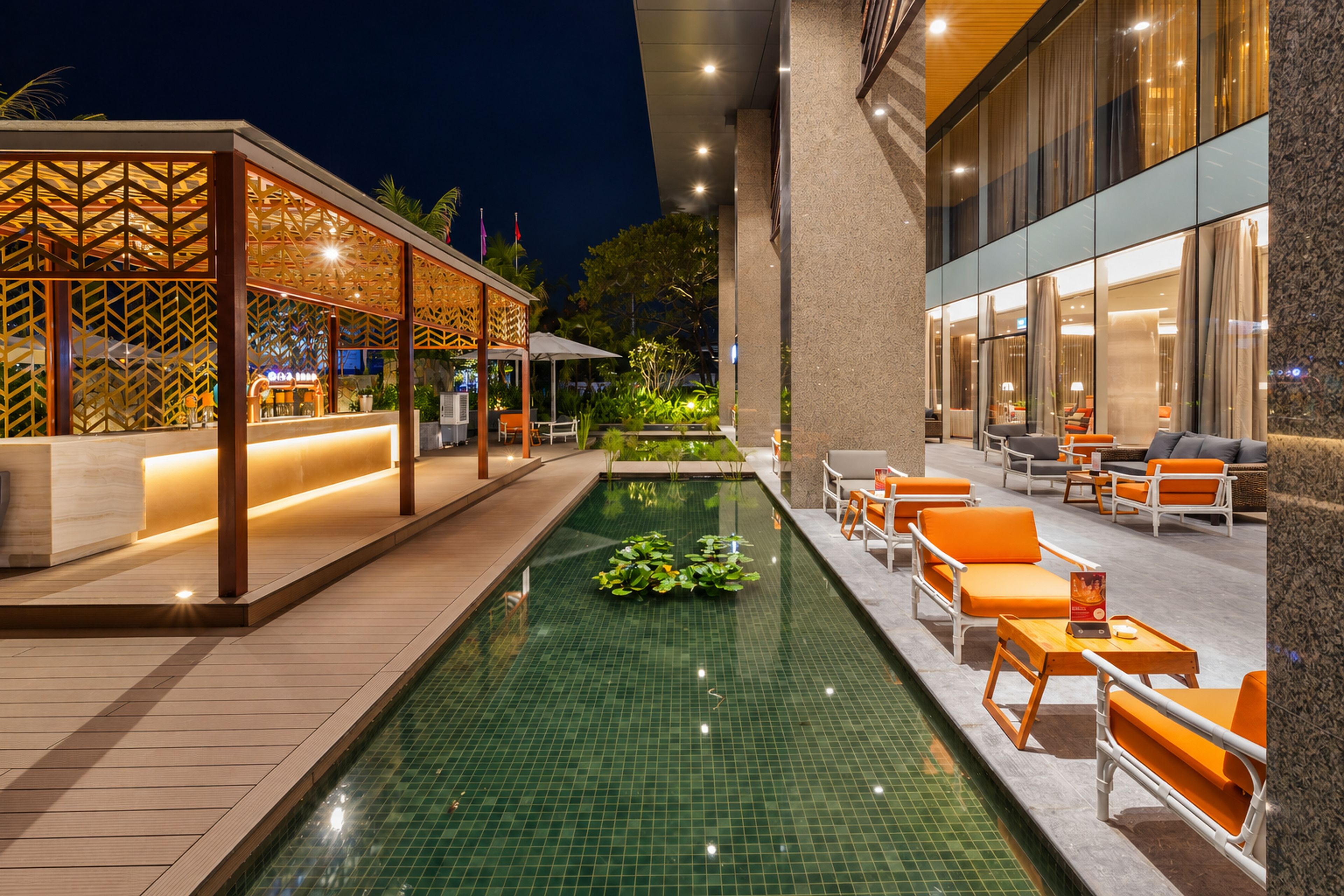 Zona junto a la piscina con fuente, mobiliario y recepción.