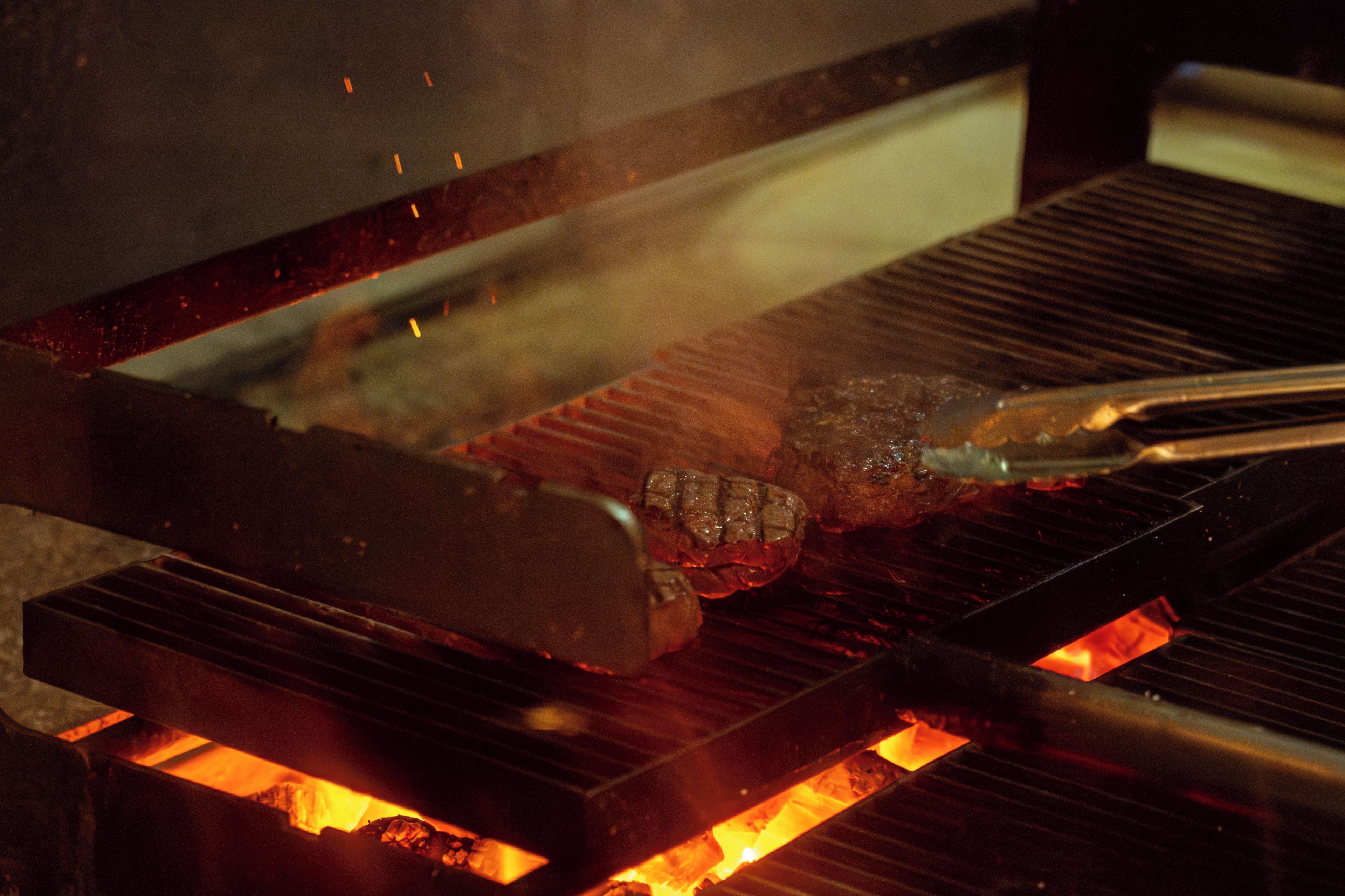 A grill with meat being cooked over an open flame.