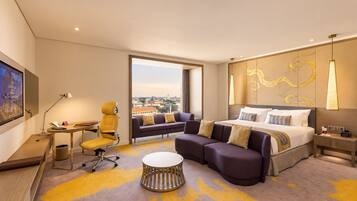 Una habitación de hotel con una cama, un sofá, un escritorio y una silla.