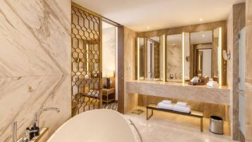 Un baño moderno con una bañera independiente, un espejo grande y un tocador con lavabo.