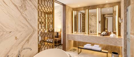 A modern bathroom with a freestanding bathtub, a large mirror, and a vanity with a sink.