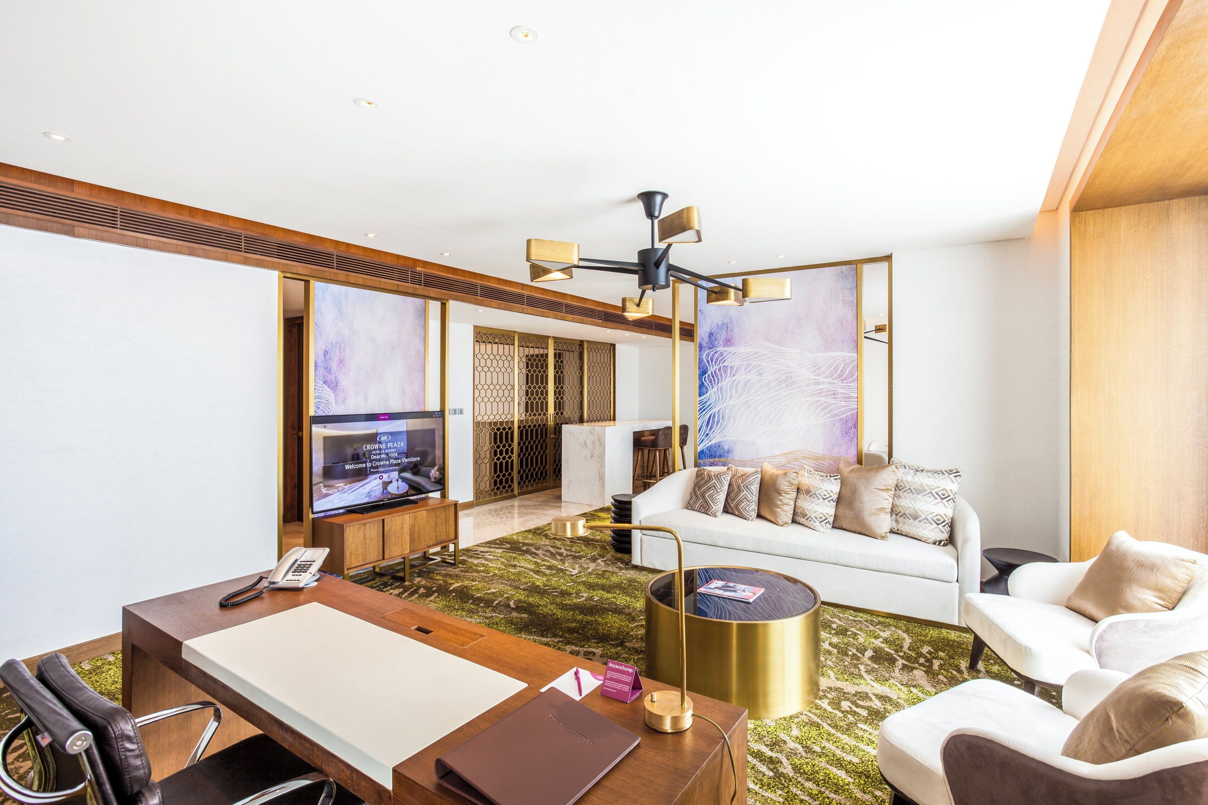 A modern living room with a sofa, coffee table, and a flat-screen TV.