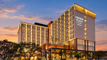 Un moderno edificio de hotel con varios pisos y un cartel llamativo que dice 'CROWNE PLAZA BY IHG Vientiane'.