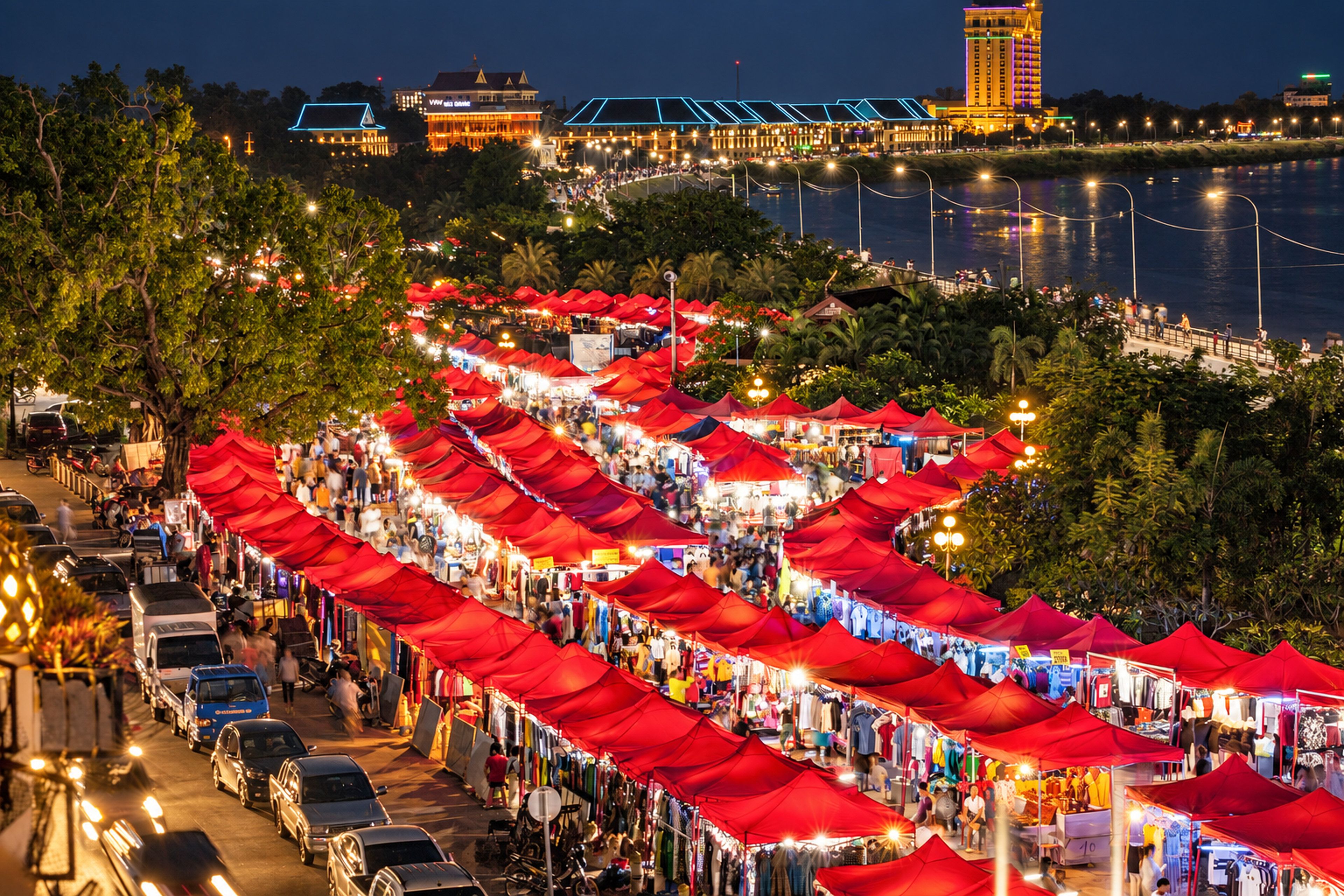 A nighttime outdoor market with red canopies and a waterfront view.