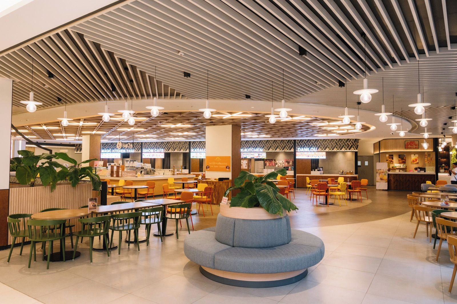 Un intérieur moderne avec un espace salon central, plusieurs tables à manger et une variété de types de sièges.