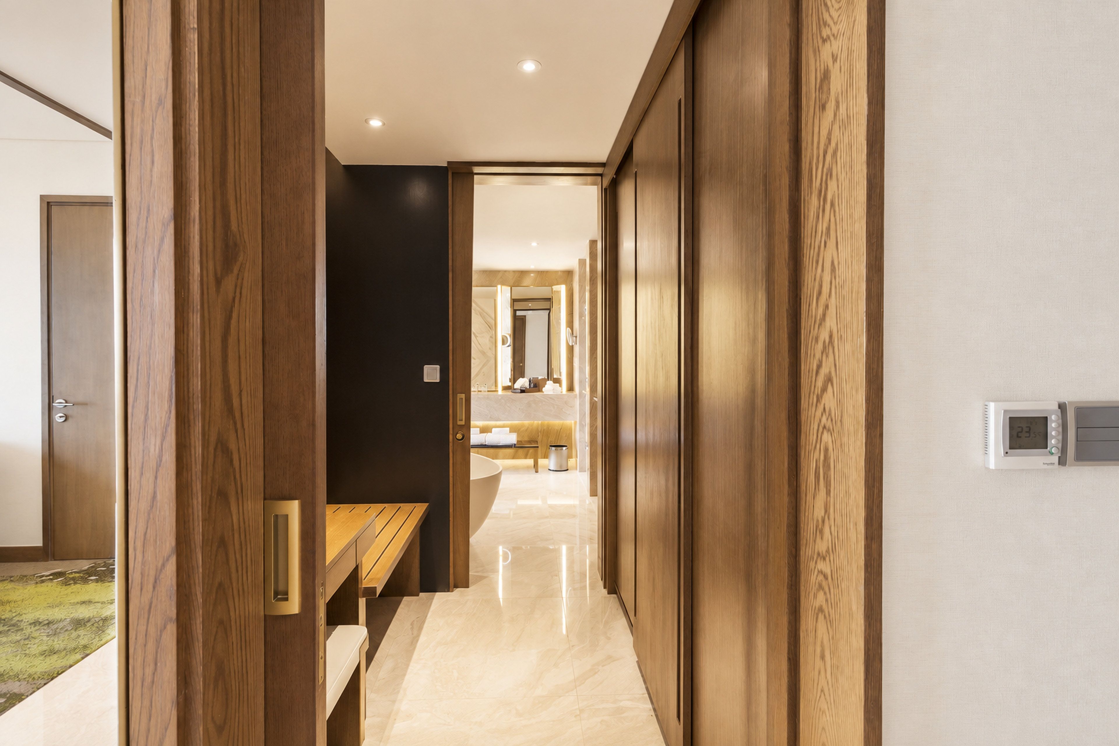 A modern bathroom with a large mirror, a sink, and a toilet.