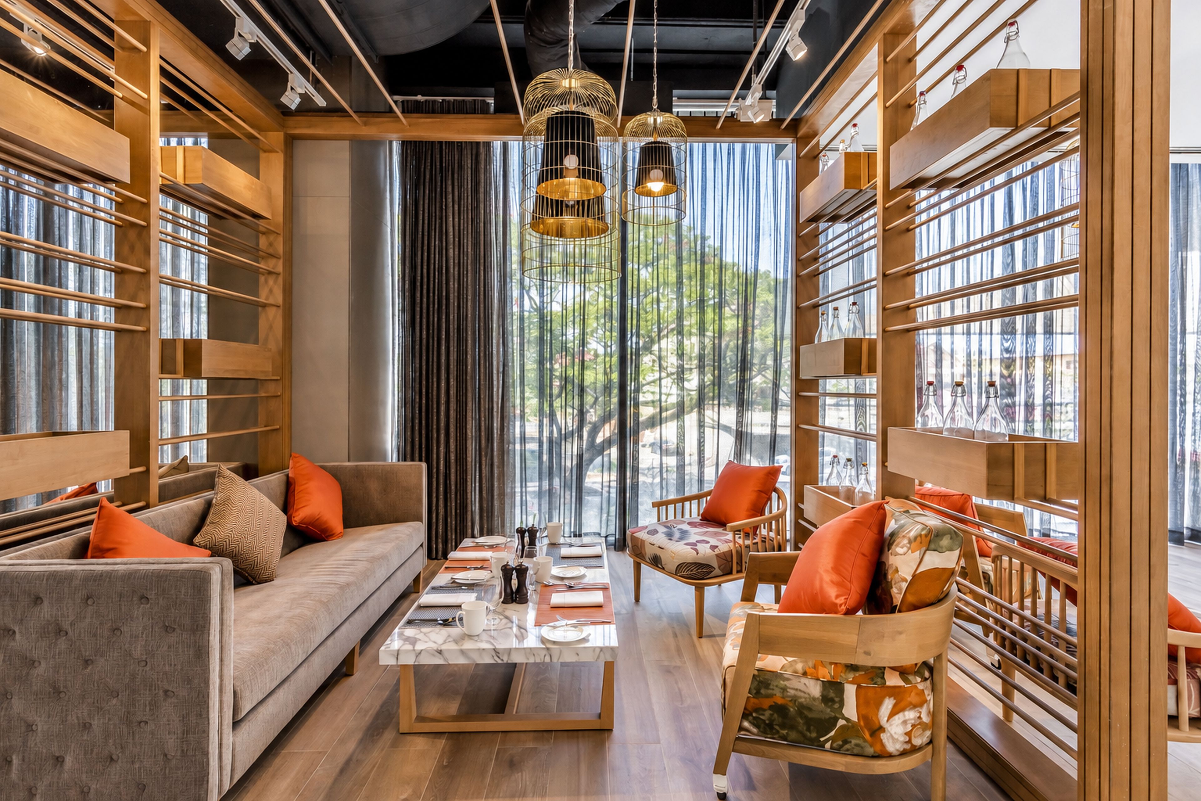 A modern interior with a sofa, armchairs, a coffee table, and a dining table set for four.