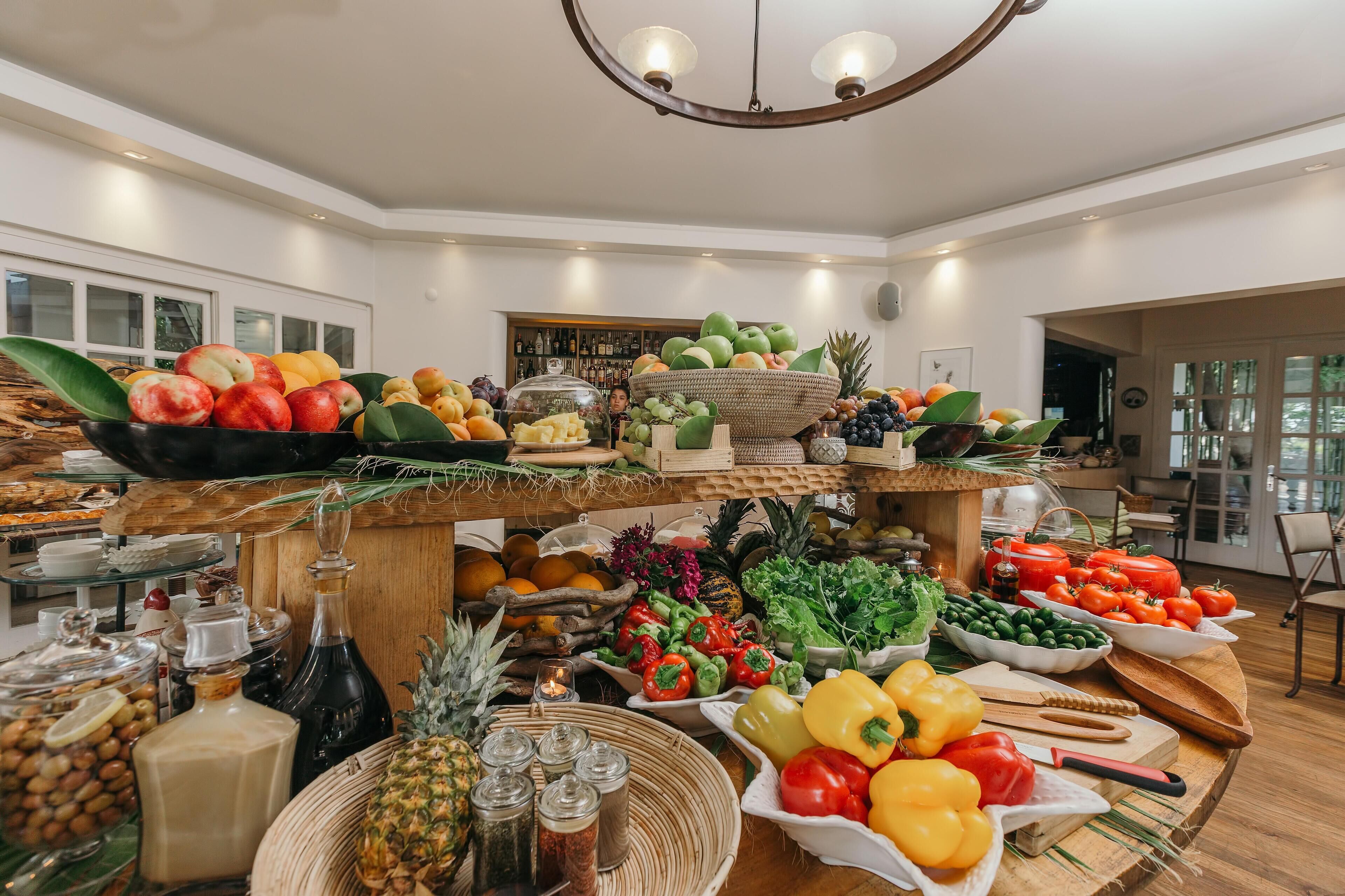 A buffet with a variety of fruits, vegetables, and condiments.