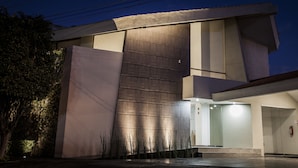 Un bâtiment moderne doté d’une grande entrée en verre et d’un toit plat.