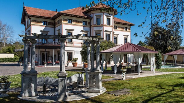 A large, multi-story building with a central courtyard, a pool, and a gazebo. - Hotel Villa Stucky (Mogliano Veneto)