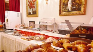 A buffet with various food items, including croissants, and a coffee machine. - Hotel Villa Stucky (Mogliano Veneto)