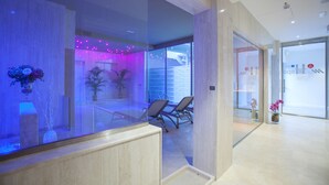 A modern hotel lobby with a reception desk, seating area, and glass doors leading to a room. - MH Florence Hotel & Spa (Florence)