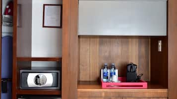 Eine kompakte Küchenzeile mit einer Mikrowelle, einem kleinen Kühlschrank und einer Kaffeemaschine.