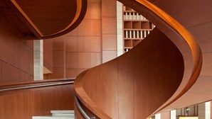 Una escalera de caracol con escalones y barandillas de madera, que conduce a un piso superior.