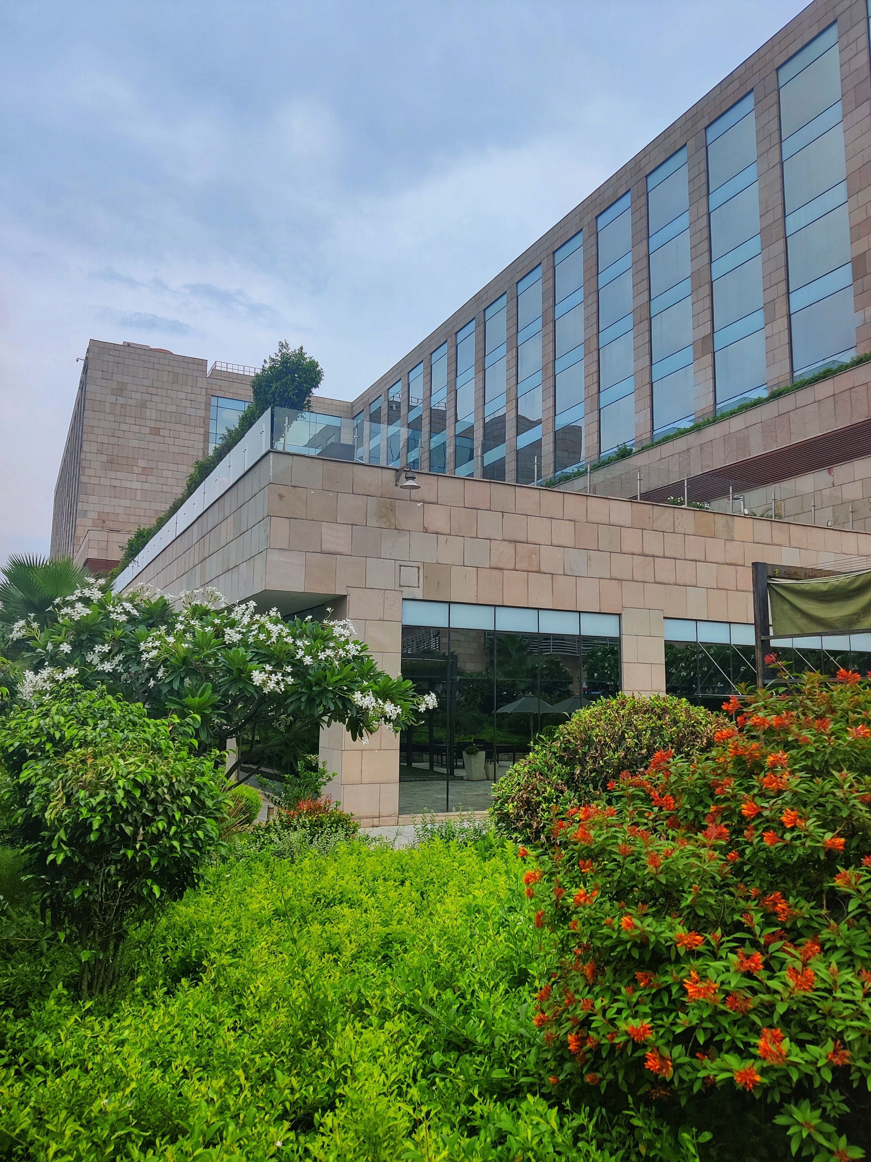 A modern building with a glass facade and a brick base.