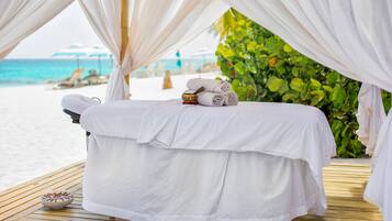Relax on a serene beachside deck with a soothing massage table and tranquil views of the ocean.